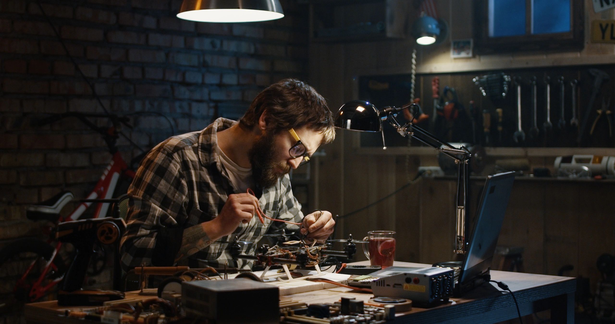 Technician soldering electronics on a repair bench